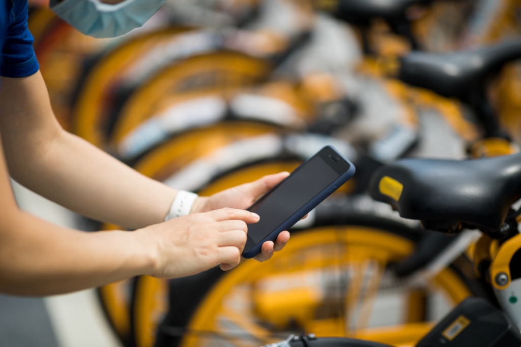 Hands using smartphone scanning the QR code of shared bike in city Hands using smartphone scanning the QR code of shared bike in city